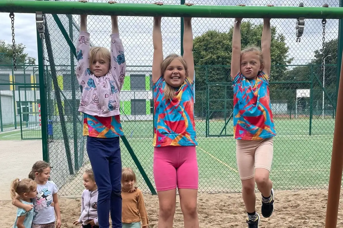 Trzy dziewczynki na drążku na placu zabaw, Ferajna Camp 2025