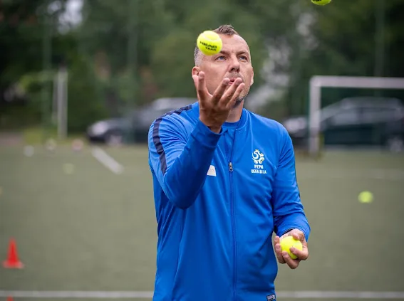 Trener Krzysztof Piosik podczas ćwiczenia koordynacyjnego z piłeczkami